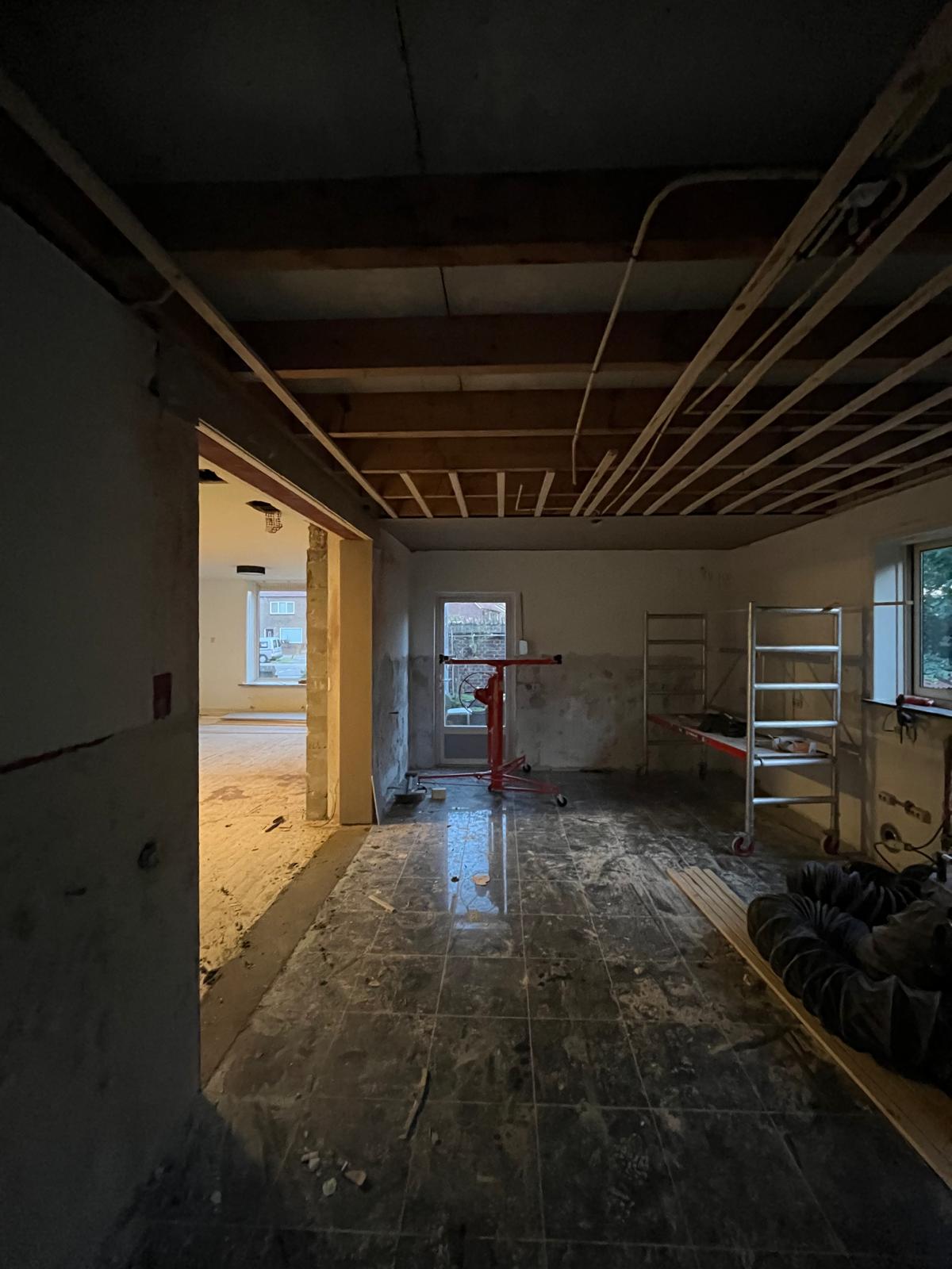 Tijdens de bouw: een nieuwe opening in een muur, met een open plafond waarin het regelwerk zit.